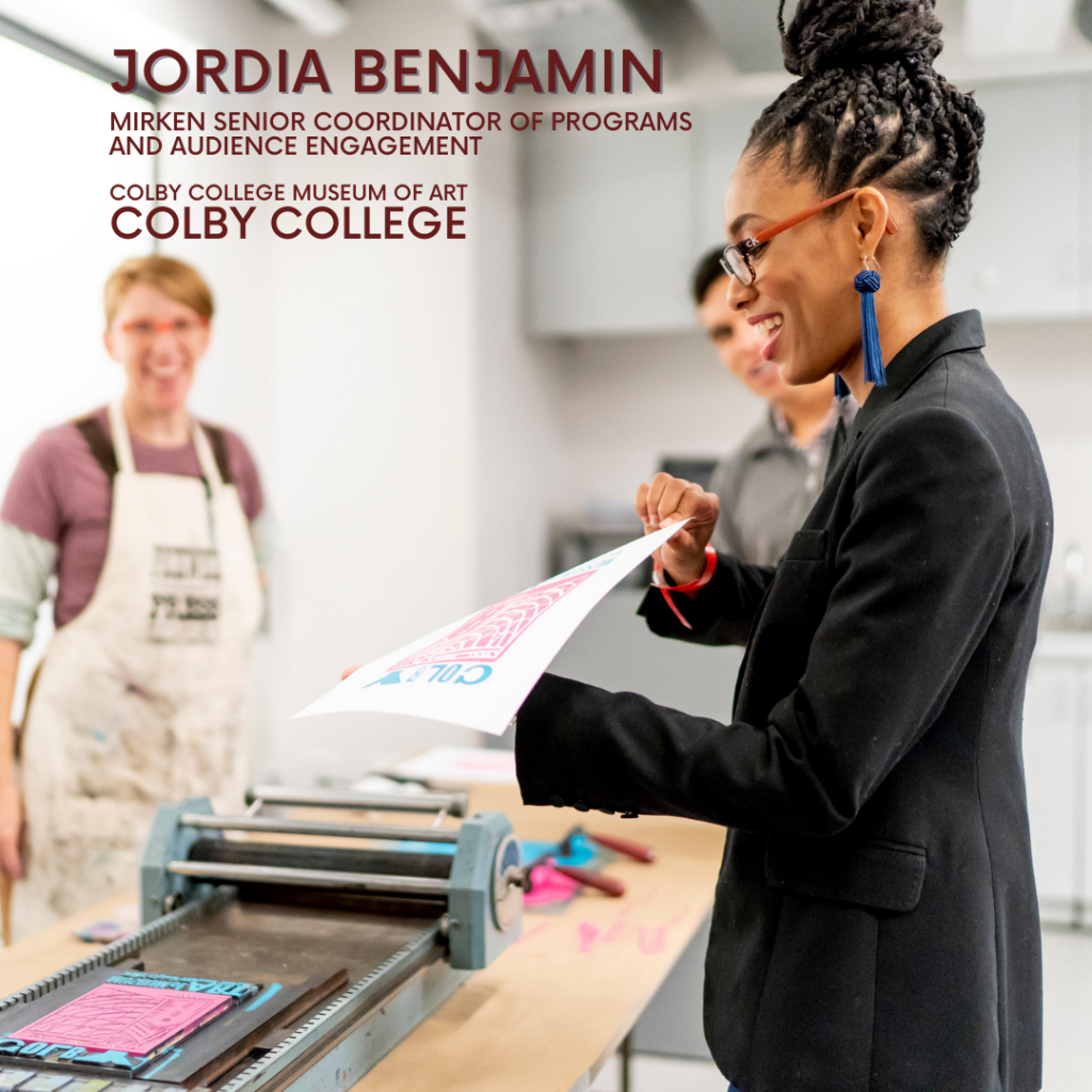 Member of the Month for June 2021, Jordia Benjamin is holding a print fresh off a printing press.